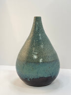 Speckled green and brown ceramic vase on a white background